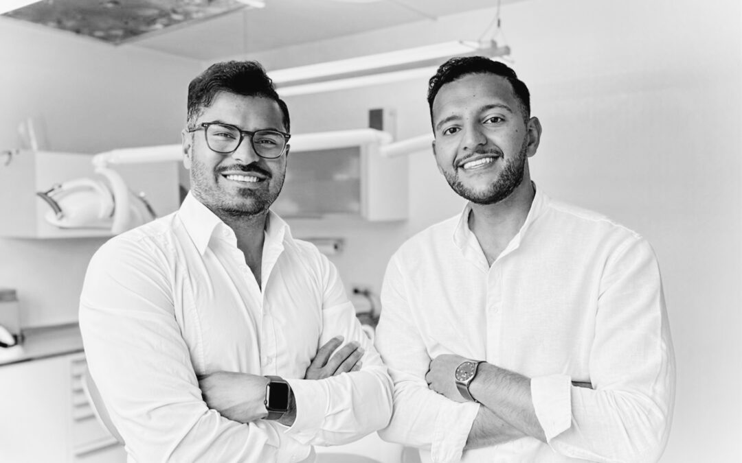 Teamfoto von den Zahnärzten Idris Najafi & Jasen Amiri sie stehen neben einander und lachen in die Kamera | Zahnarzt Hittfeld | Zahnarztpraxis Seevedental